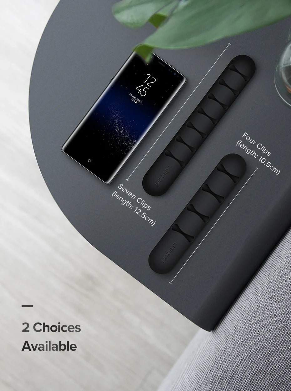 Black phone stand with clips on a gray surface
