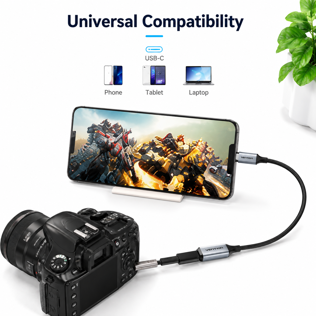 A black USB-C adapter cable shown connecting a smartphone and a DSLR camera, with text reading 'Universal Compatibility' and small icons for Phone, Tablet, and Laptop. The product is presented on a clean white background with a small green plant in the corner.