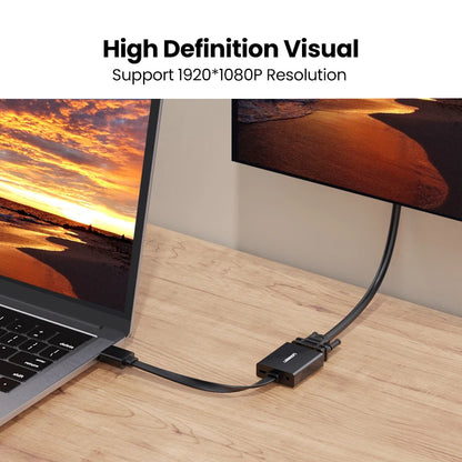 A black dual monitor adapter cable connecting a laptop and a desktop monitor on a wooden desk, with text at the top reading 'High Definition Visual Support 1920*1080P Resolution'.
