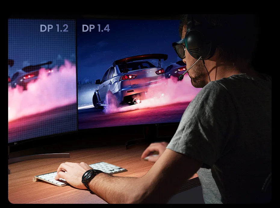 A person wearing a headset sits at a desk in a dim room, using a keyboard and mouse in front of a curved monitor showing a racing car scene. A second monitor beside it displays a lower-resolution version with 'DP 1.