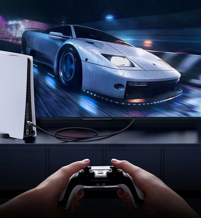 Person playing a racing game on a TV with a controller, showing a high-tech car on the screen.