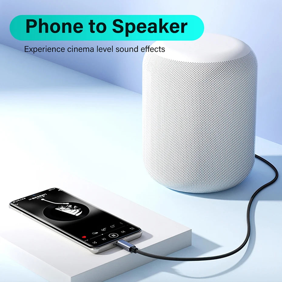 A white cylindrical speaker connected to a smartphone via a black cable, shown on a clean light blue studio background with promotional text reading 'Phone to Speaker'.