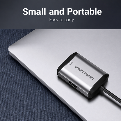 A small silver and black Vention USB adapter plugged into a silver laptop on a dark textured surface, with text at the top reading 'Small and Portable' and 'Easy to carry'.