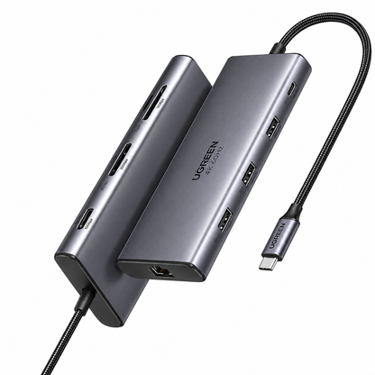 A UGREEN 7-in-1 USB-C hub in dark gray aluminum, shown with two angled views of the hub body and a black braided USB-C cable on a plain white background.
