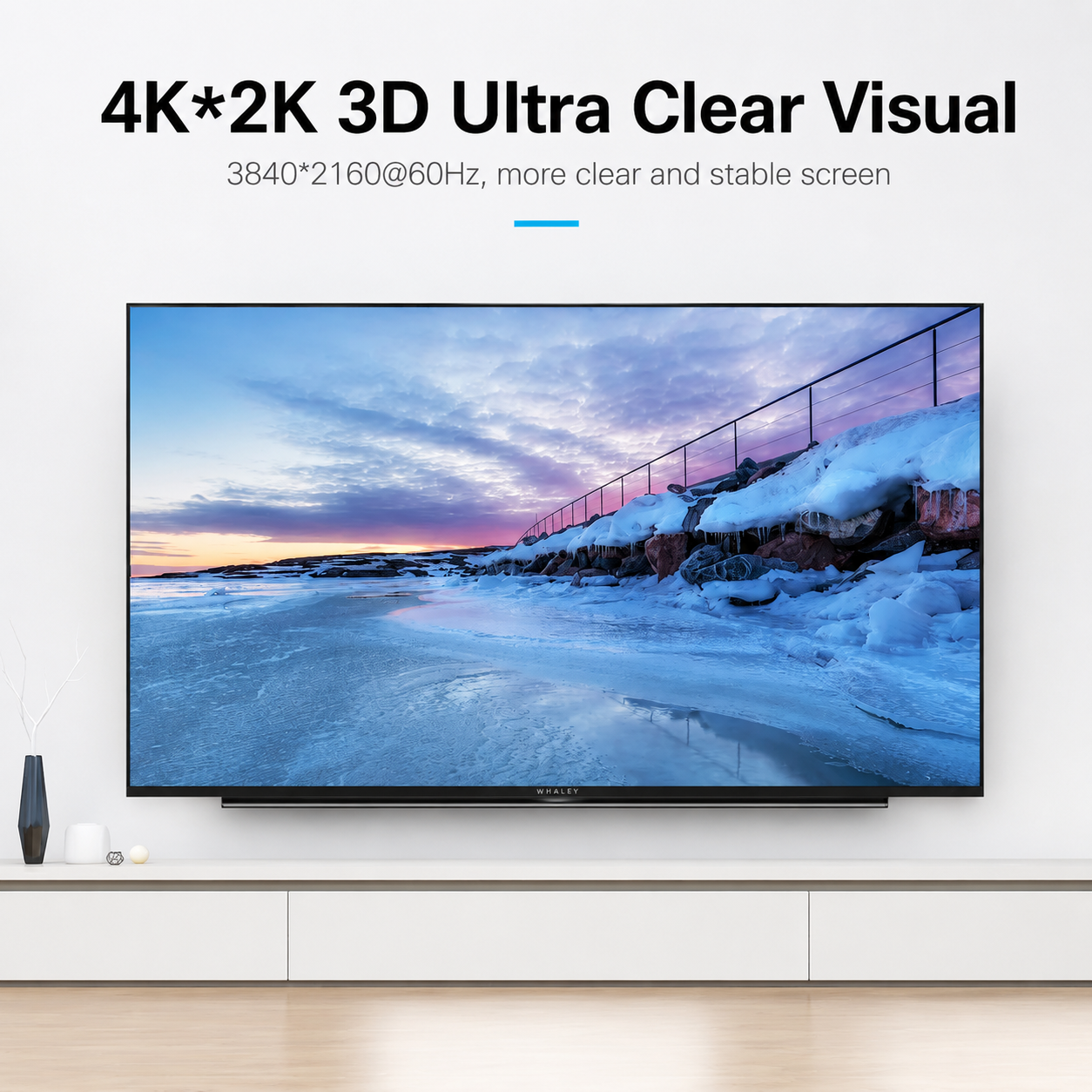 A large flat-screen TV mounted on a white wall above a white console, showing a snowy coastal landscape on the screen. Text at the top reads '4K*2K 3D Ultra Clear Visual' with additional screen spec text.