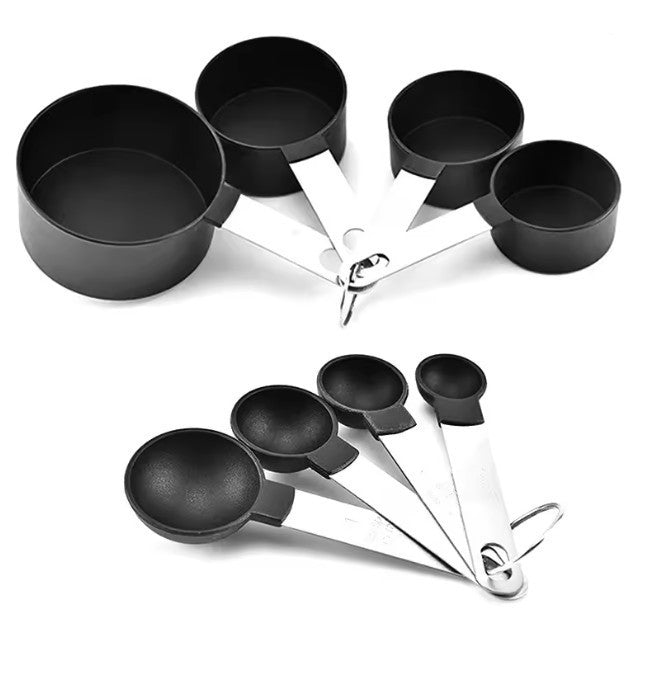 Set of black measuring cups and spoons on a white background
