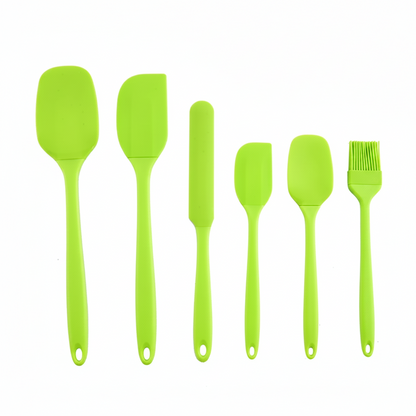 Set of green silicone kitchen utensils on a white background