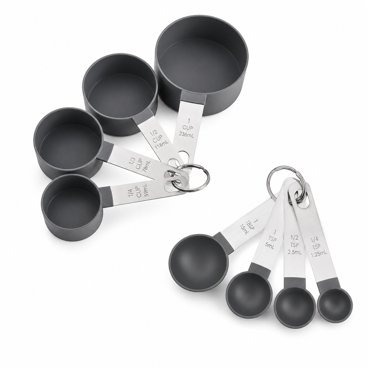A set of dark gray measuring cups and spoons with silver metal handles and rings, shown on a clean white background. The cups are arranged in two groups, with one larger cup standing upright and the smaller spoons fanned out.