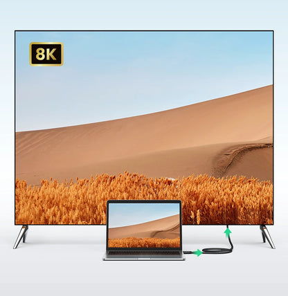 Large TV displaying a desert scene with an 8K label, connected to a laptop showing the same image.